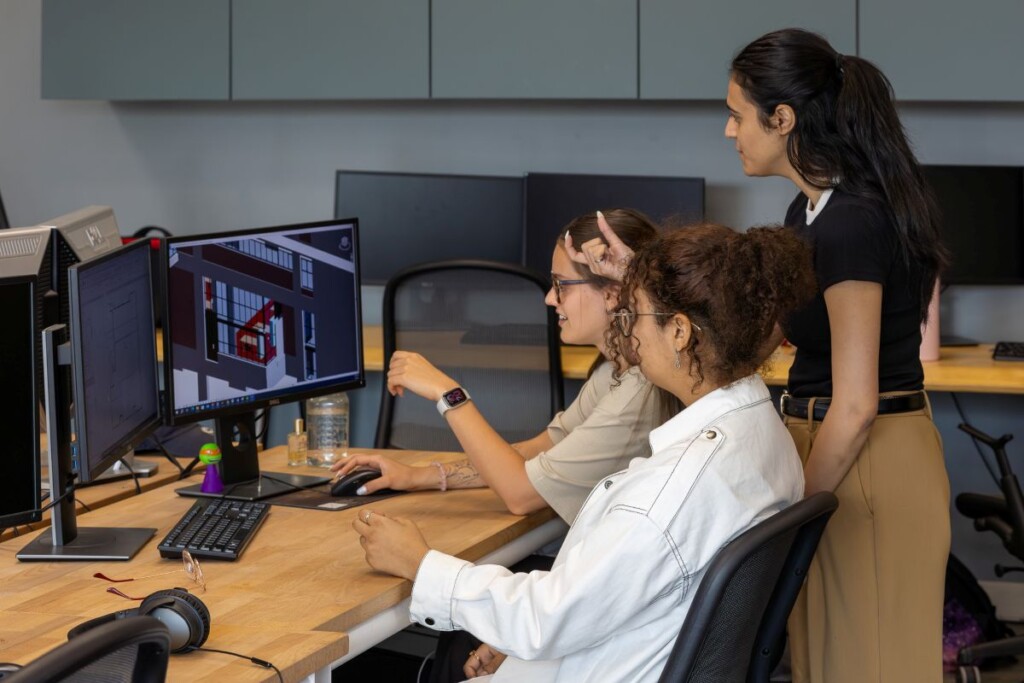 Three CIMS lab UNESCO Chair students sit looking at a computer