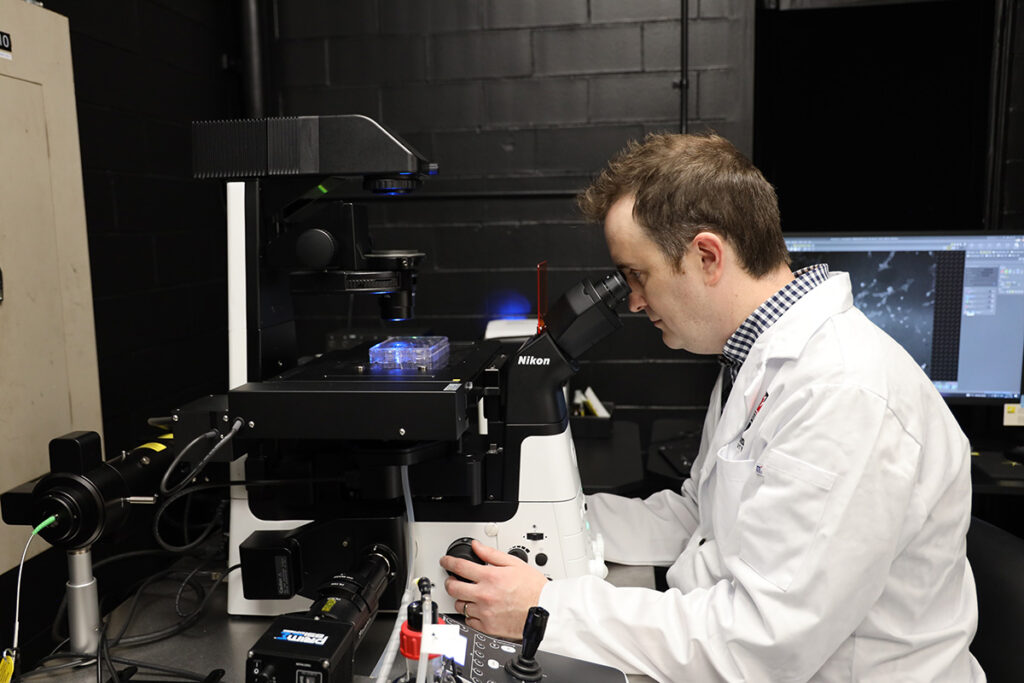 Andrew Harris looking through a microscope