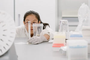 Yaxi Hu working in a lab holding and looking at a test tub