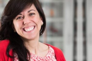 headshot of maria derosa smiling wearing a red sweater