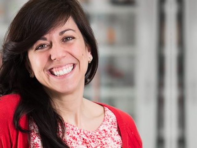 headshot of maria derosa smiling wearing a red sweater